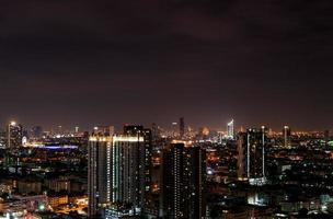 paisagem urbana do edifício moderno no meio da noite. prédio de escritórios de arquitetura moderna. arranha-céu com lindo céu noturno. edifício do centro comercial e financeiro. apartamento na cidade com luz noturna. foto