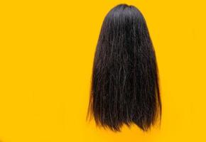 cabelo danificado isolado em fundo amarelo. problema de cabelo seco e quebradiço. cabelo comprido preto com textura seca. mulher asiática com cabelo fraco e quebradiço precisa de condicionador de tratamento e spa. cabelo insalubre. foto