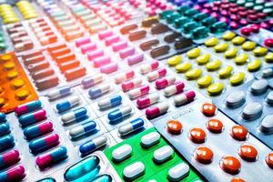 colorido de comprimidos e cápsulas pílula em embalagens blister organizadas com belo padrão com luz de sinalização. conceito de indústria farmacêutica. farmácia drogaria. resistência a antibióticos. foto