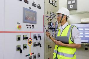 eletricista experiente trabalhando na sala de controle da usina. engenheiro trabalhando na subestação de distribuição de energia elétrica do painel de controle de status. foto