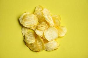 lanche de batatas fritas em fundo amarelo, vista superior de batata crocante foto