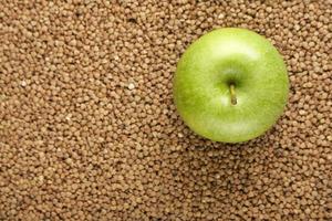 dieta simples e conceito de estilo de vida saudável flatlay maçã verde em fundo de trigo sarraceno. foto
