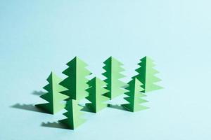 floresta de papel com espaço livre para copiar e colar para texto. árvores de papel verde sobre fundo azul. foto