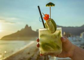 coquetel de caipirinha com rio de janeiro, fundo de praia brasileira foto