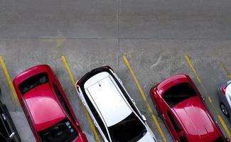 vista superior do carro estacionado no estacionamento de concreto com linha amarela de sinal de trânsito na rua. vista acima do carro em uma fileira no estacionamento. sem vaga de estacionamento disponível. área de estacionamento exterior. foto