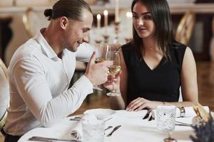 jovem e lindo. lindo casal jantar romântico no restaurante de luxo à noite foto