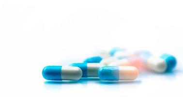 foco seletivo na pílula de cápsulas azuis e brancas sobre fundo branco. resistência a antibióticos. pílulas cápsula antimicrobiana. indústria farmacêutica. produtos de farmácia. farmacêutica. foto