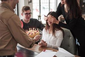 surpresa está chegando. um dos funcionários faz aniversário hoje. colegas de trabalho amigáveis decide fazer surpresa para ela foto