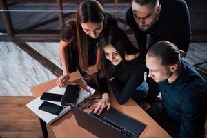 vista do topo. equipe de jovens empresários trabalha em seu projeto à noite no escritório foto