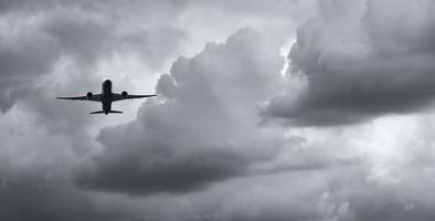 avião voando no céu escuro e nuvens brancas. companhia aérea comercial com conceito de destinos de sonho. conceito de crise de negócios de aviação. voo de férias de viagem falhou. transporte aéreo. viagem triste. foto