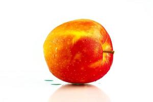 uma maçã vermelha com água cai na pele isolada no fundo branco, com espaço de cópia. fruta saudável e conceito de comida saudável. comida vegana. foto