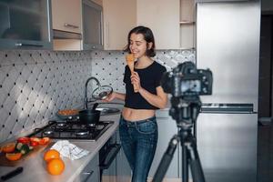 já tem um gosto bom. garota na cozinha moderna em casa em seu horário de fim de semana pela manhã foto