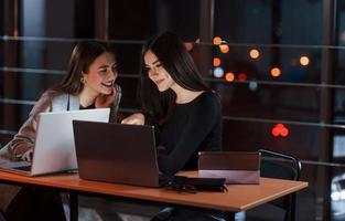 É realmente engraçado. equipe de jovens empresários trabalha em seu projeto à noite no escritório foto