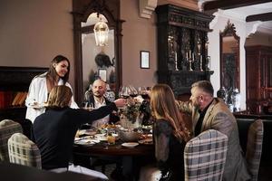 desfrute de sua refeição. amigos da família se divertindo no belo restaurante moderno de luxo foto