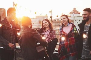 festa na cobertura com violão e música. belos jovens foto