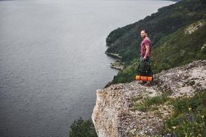 homem atraente, apreciando a vista da paisagem de montanhas acima da superfície da água. conceito de férias de aventura de estilo de vida de viagens foto