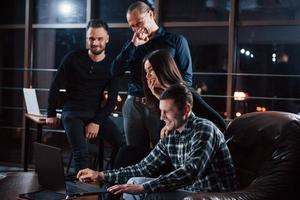 apenas um pouco de descanso após o trabalho. equipe de jovens empresários trabalha em seu projeto à noite no escritório foto