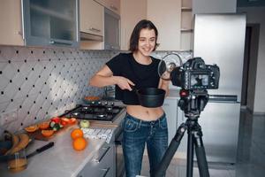 o que eu cozinhei hoje. garota na cozinha moderna em casa em seu horário de fim de semana pela manhã foto