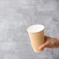 embalagens de alimentos ecologicamente corretas ou xícara de café para viagem. mão segurando o recipiente natural para ir. desperdício zero, poluição, dia da terra, plástico grátis, conceito de dia mundial do meio ambiente foto