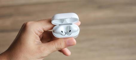 fone de ouvido sem fio branco ou fones de ouvido na mesa para uso com smartphone. conceito de tecnologia foto