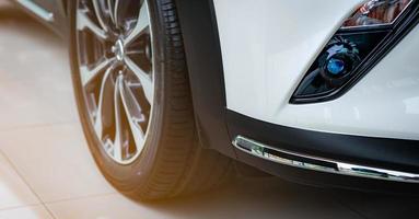 novo carro branco de luxo estacionado no showroom moderno para venda. escritório de concessionária de automóveis. loja de varejo de automóveis. tecnologia de carro elétrico ou híbrido e conceito de negócio. conceito de aluguel de automóveis. indústria automobilística. foto