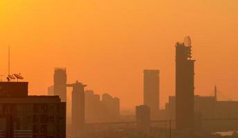 poluição do ar em bangkok, tailândia. smog e poeira fina da cidade coberta de pm2.5 pela manhã com o céu laranja do nascer do sol. paisagem urbana com ar poluído. ambiente sujo. poeira tóxica urbana. ar insalubre. foto