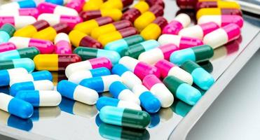 pílulas de cápsula antibiótica colorida na bandeja de drogas de aço inoxidável. medicamentos prescritos. resistência a antibióticos. indústria farmacêutica. foto