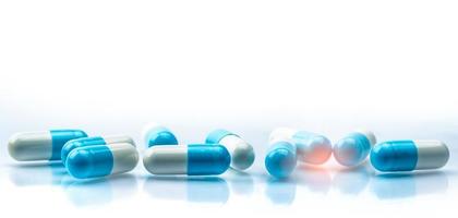 foco seletivo na pílula de cápsulas azuis e brancas sobre fundo branco. resistência a antibióticos. pílulas cápsula antimicrobiana. indústria farmacêutica. produtos de farmácia. farmacêutica. foto