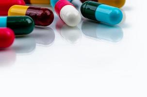 pílulas de cápsula de antibiótico colorido sobre fundo branco. conceito farmacêutico. resistência a antibióticos. indústria farmacêutica. farmácia drogaria. medicamento de saúde. cápsula antimicrobiana. foto