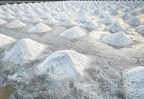 fazenda de sal marinho na tailândia. sal marinho orgânico. evaporação e cristalização da água do mar. matéria-prima de sal industrial. Cloreto de Sódio. sistema de evaporação solar. fonte de iodo. pilha de sal closeup foto