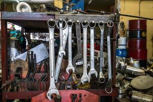 muitas das chaves penduradas no cabide de metal, ferramentas desarrumadas ao fundo foto