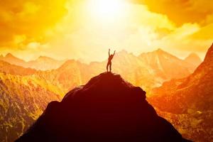 mulher feliz no pico da montanha desfrutando do sucesso, liberdade e futuro brilhante. foto