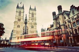 igreja da abadia de westminster, ônibus vermelho em movimento em londres, reino unido. vintage foto