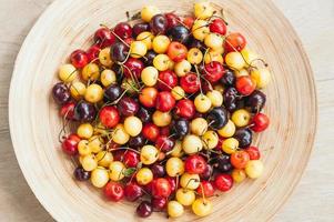 cerejas multicoloridas na tigela. cerejas brancas e vermelhas. tiro de perto. frutas sazonais de verão. comida saudável. foco seletivo foto