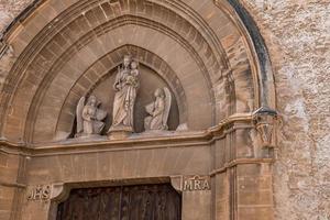 close-up de ângulo baixo do exterior da catedral com a estátua de mãe maria e jesus foto