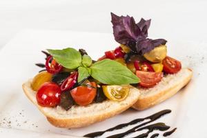 tomates suculentos no pão fresco, pesto como cobertura foto