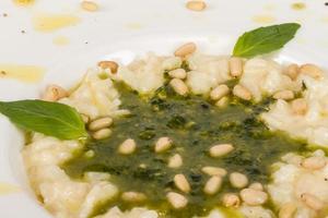 foto de delicioso prato de risoto com ervas e noz de cedro em fundo branco