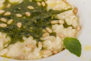 foto de delicioso prato de risoto com ervas e noz de cedro em fundo branco