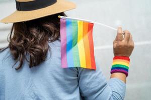 senhora asiática com coração de bandeira do arco-íris, símbolo do mês do orgulho lgbt comemora anual em junho social de gays, lésbicas, bissexuais, transgêneros, direitos humanos. foto