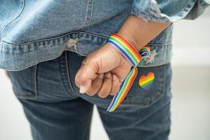 senhora asiática usando pulseiras de bandeira do arco-íris, símbolo do mês do orgulho LGBT, comemora anual em junho social de gays, lésbicas, bissexuais, transgêneros, direitos humanos. foto