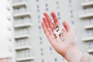 uma corretora de imóveis segurando as chaves de um novo apartamento em suas mãos. foto