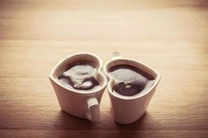 café preto, expresso em duas xícaras em forma de coração foto