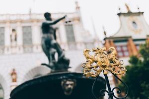 crista da cidade de gdansk e estátua de netuno turva. foto