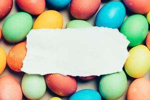 papel branco em cima de ovos coloridos. foto