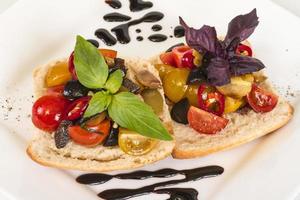 tomates suculentos no pão fresco, pesto como cobertura foto