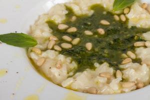 foto de delicioso prato de risoto com ervas e noz de cedro em fundo branco