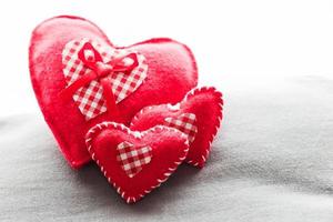 corações vermelhos de pelúcia feitos à mão no travesseiro macio. Amor romântico foto