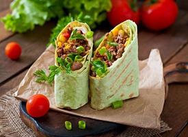 burritos envolve com carne picada e legumes em um fundo de madeira foto