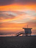 Torre de salva-vidas na praia ao pôr do sol foto