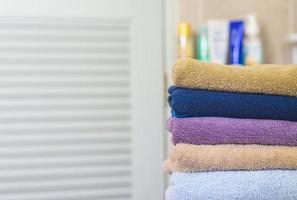 pilha de toalhas no ambiente desfocado do banheiro foto